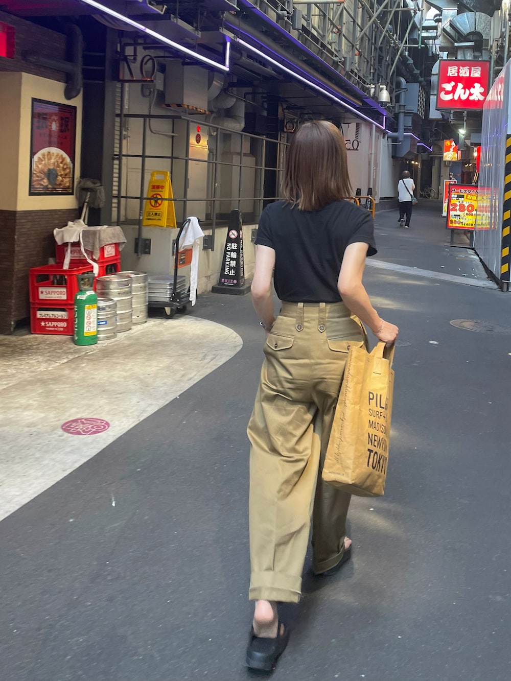 ベージュ系のチノパンツ、ブラック系のサンダル、シルバー系のブレスレットを着用したレディースの夏コーディネートの2枚目の写真