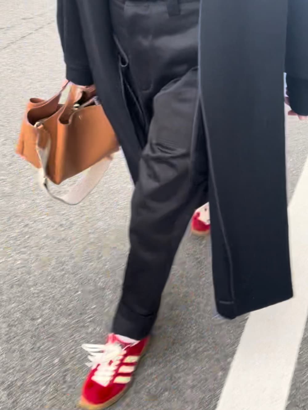 ブラック系のジャケット/アウター、ブラック系のパンツ、レッド系のスニーカーを着用したレディースの秋コーディネートの2枚目の写真