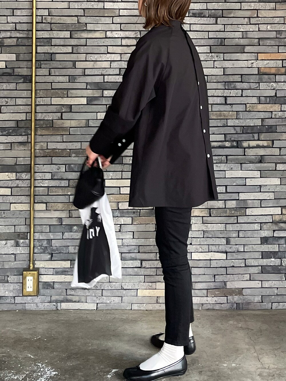 ブラック系のシャツ/ブラウス、ブラック系のボストンバッグ、ブラック系のバレエシューズを着用したレディースの春コーディネートの2枚目の写真