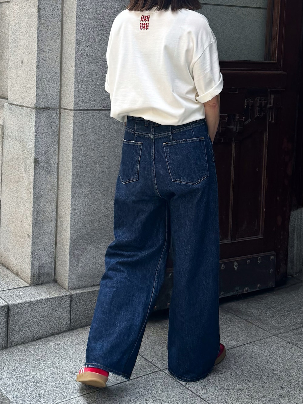 ホワイト系のTシャツ/カットソー、ブルー系のデニムパンツ、レッド系のスニーカーを着用したレディースの夏コーディネートの5枚目の写真