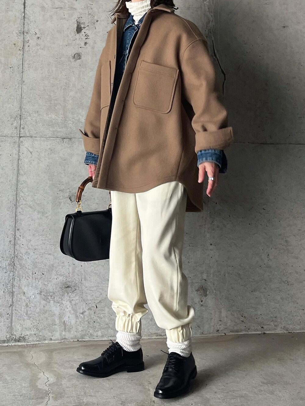 ブラウン系のジャケット/アウター、ホワイト系のパンツ、ブラック系のドレスシューズを着用したレディースの秋コーディネートの5枚目の写真