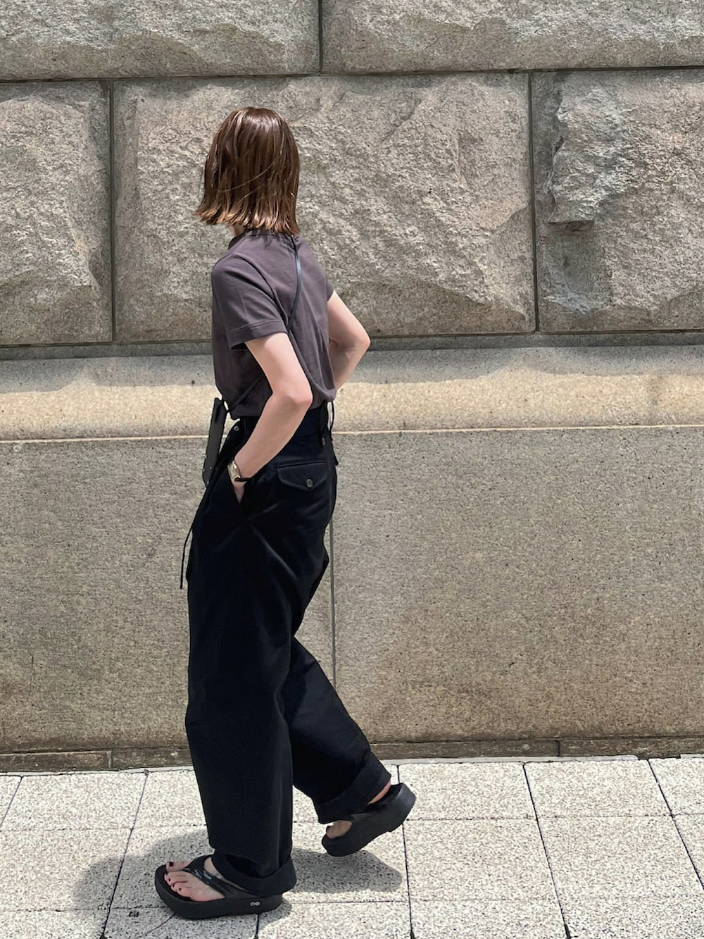 ブラウン系のTシャツ/カットソー、ブラック系のチノパンツ、ブラック系のサンダルを着用したレディースの夏コーディネートの2枚目の写真