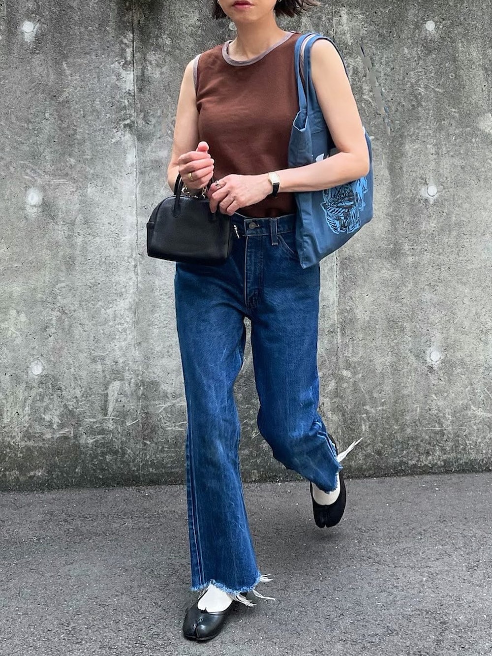 ブラウン系のTシャツ/カットソー、ブラック系のボストンバッグ、ブルー系のトートバッグを着用したレディースの夏コーディネートの2枚目の写真