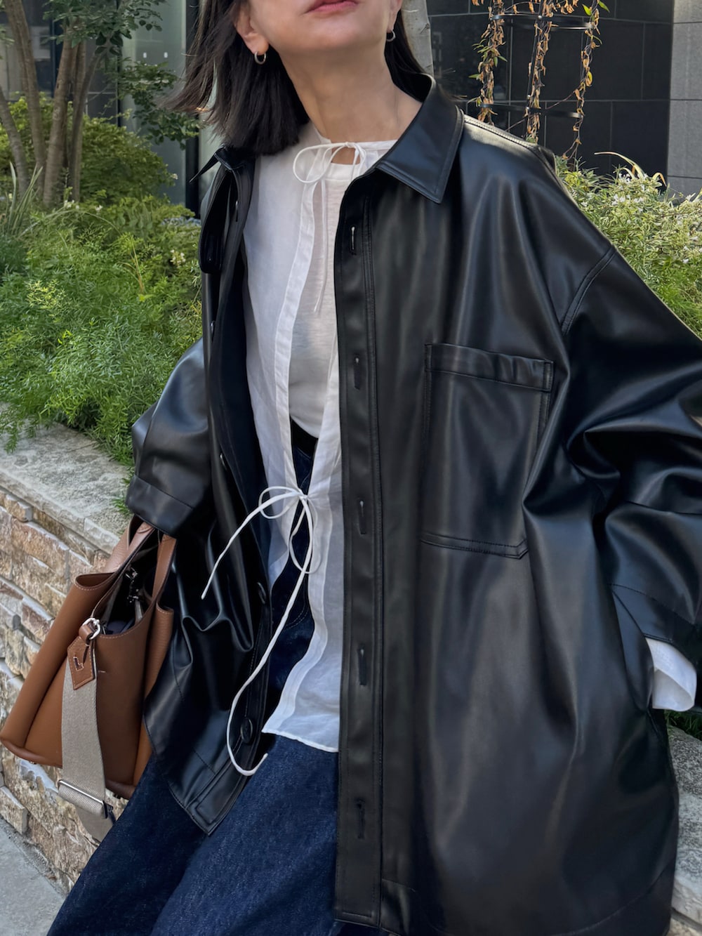 ブラック系のジャケット/アウター、ホワイト系のシャツ/ブラウス、ブルー系のデニムパンツを着用したレディースの秋コーディネートの2枚目の写真