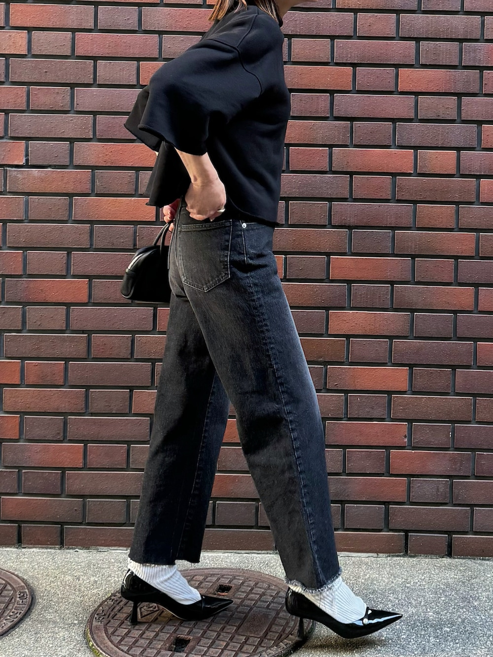 ブラック系のTシャツ/カットソー、ブラック系のデニムパンツ、シルバー系のリングを着用したレディースの春コーディネートの4枚目の写真