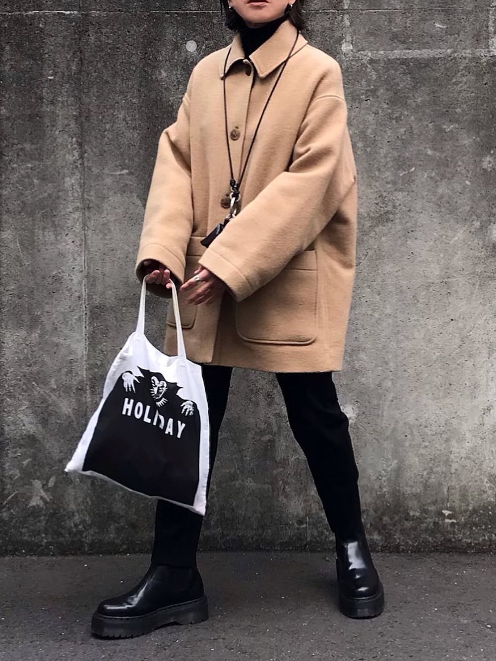 ホワイト系のトートバッグ、ブラック系のブーツを着用したレディースの冬コーディネートの2枚目の写真