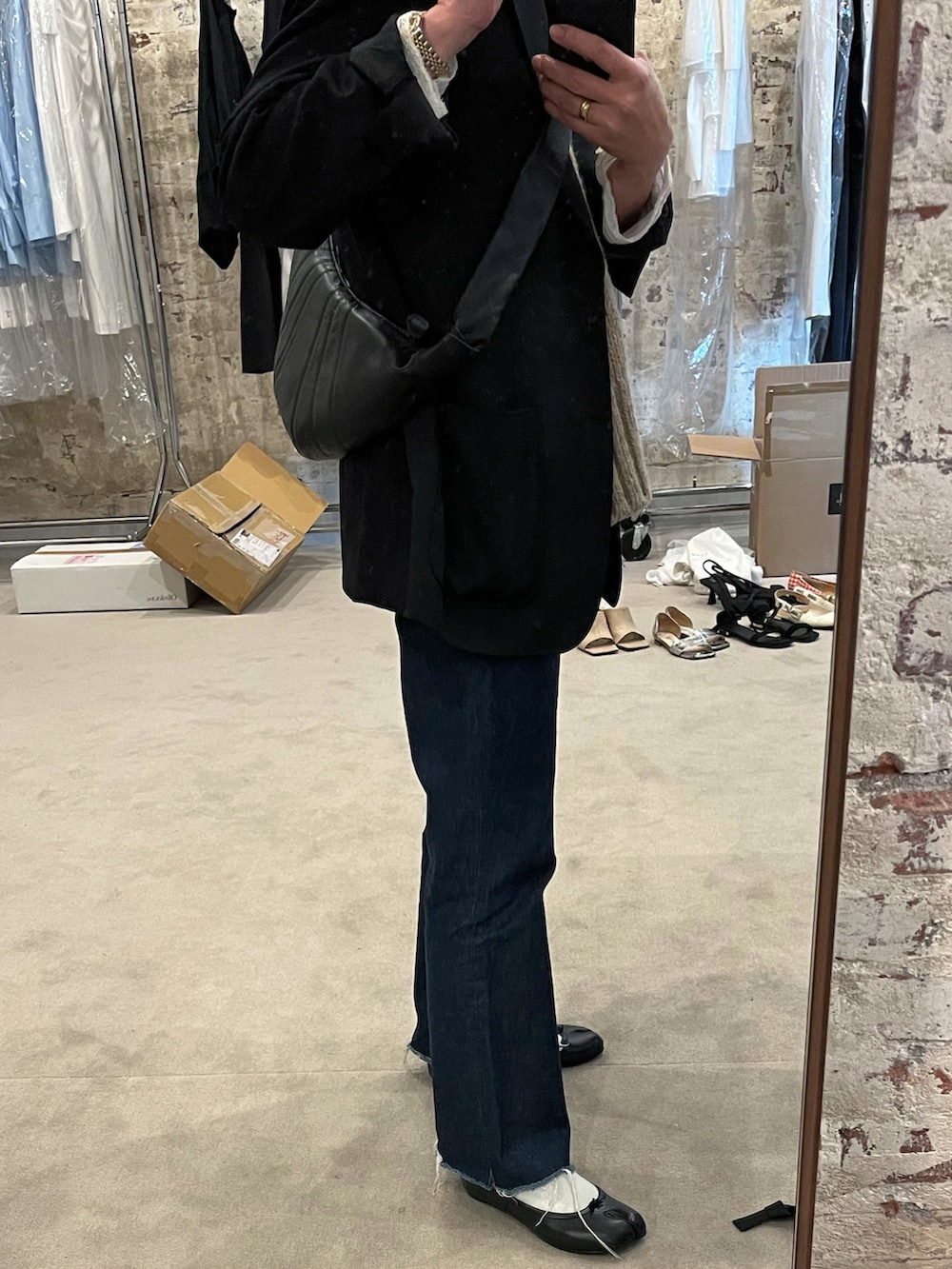 ブラック系のテーラードジャケット、ブラック系のバレエシューズ、ブラック系のショルダーバッグを着用したレディースの春コーディネートの3枚目の写真