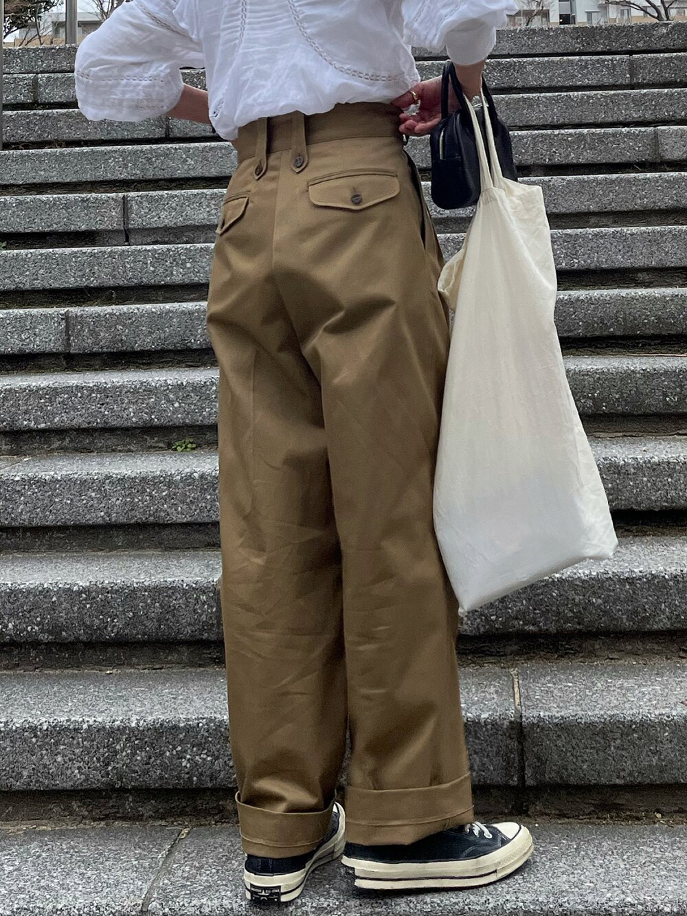 ベージュ系のチノパンツ、ブラック系のボストンバッグを着用したレディースの冬コーディネートの5枚目の写真