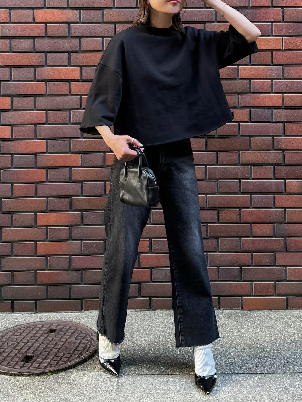 ブラック系のTシャツ/カットソー、ブラック系のデニムパンツ、シルバー系のリングを着用したレディースの春コーディネートの2枚目の写真