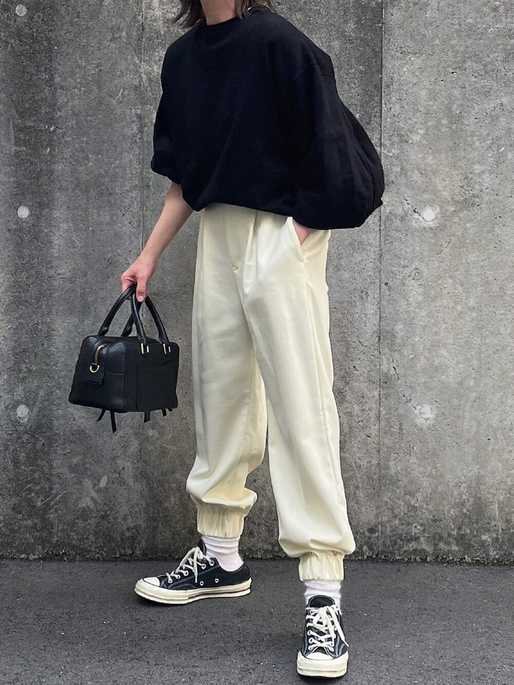 ホワイト系のパンツ、ブラック系のショルダーバッグを着用したレディースの秋コーディネートの2枚目の写真