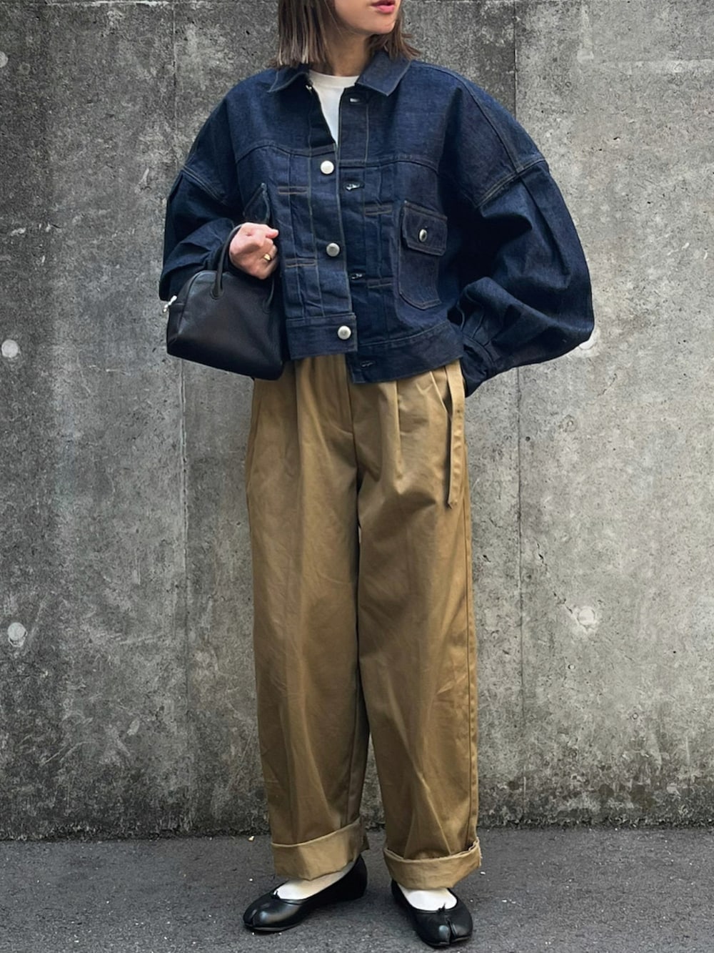 ベージュ系のチノパンツ、ブラック系のバレエシューズを着用したレディースの春コーディネートの2枚目の写真