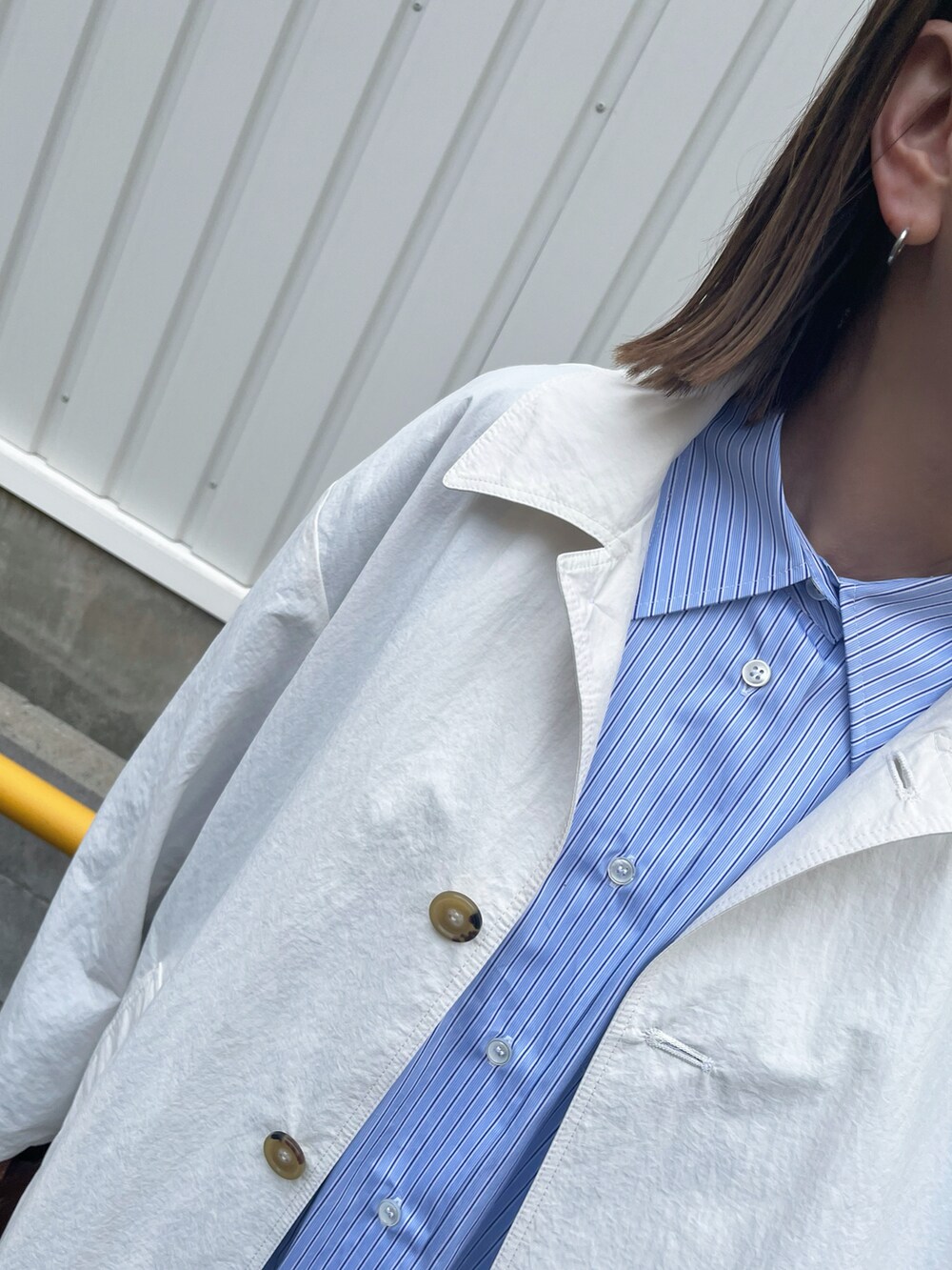 ブルー系のシャツ/ブラウス、ホワイト系のジャケット/アウター、レッド系のスニーカーを着用したレディースの冬コーディネートの3枚目の写真