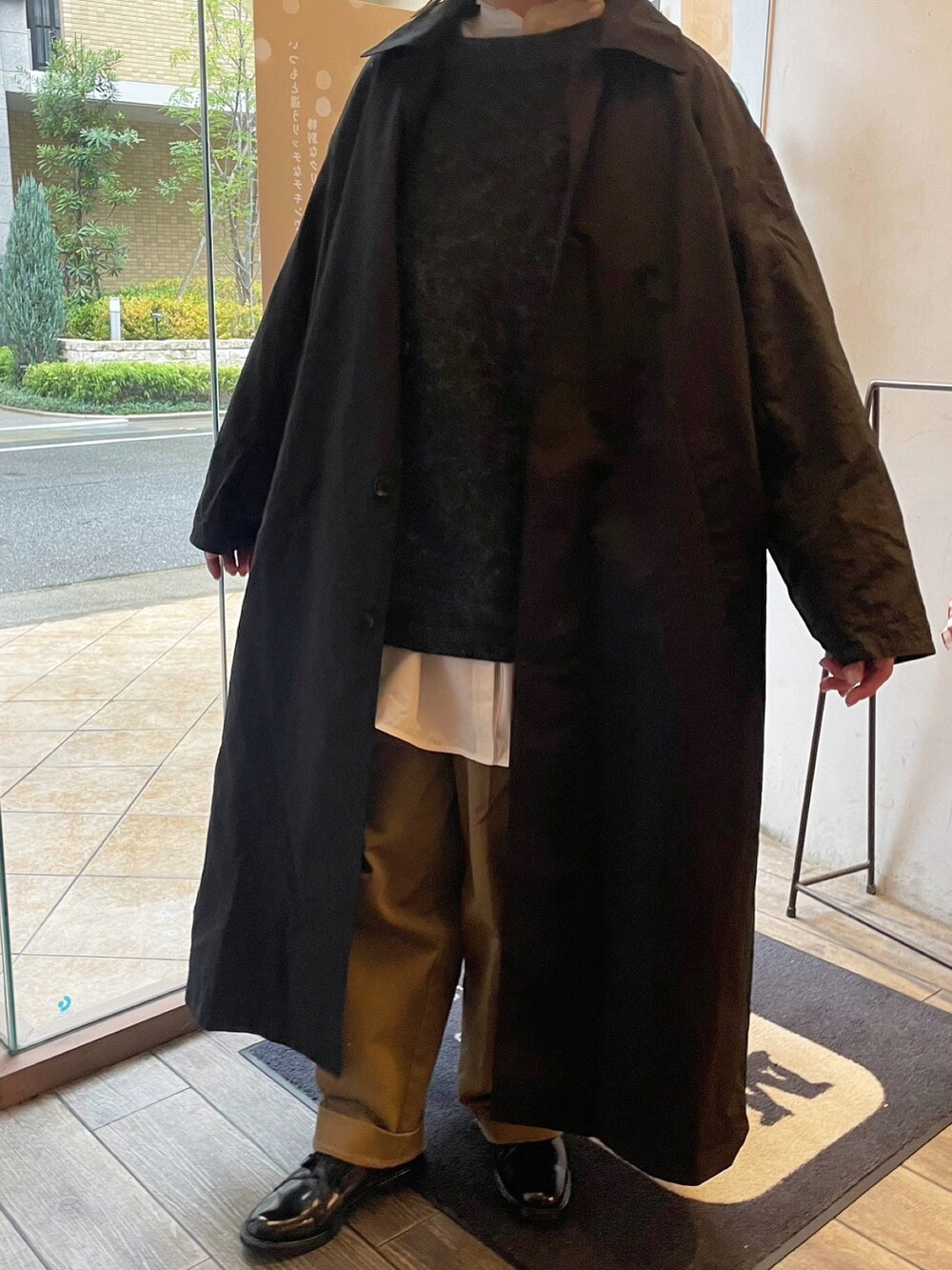 ホワイト系のシャツ/ブラウス、ベージュ系のチノパンツ、ブラック系のドレスシューズを着用したレディースの冬コーディネートの3枚目の写真