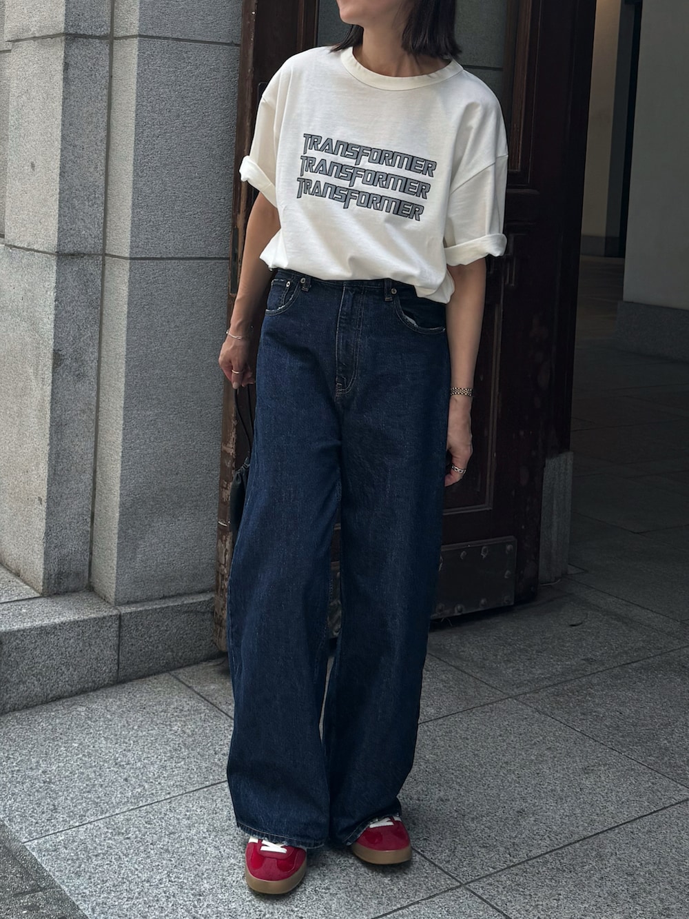 ホワイト系のTシャツ/カットソー、ブルー系のデニムパンツ、レッド系のスニーカーを着用したレディースの夏コーディネートの3枚目の写真