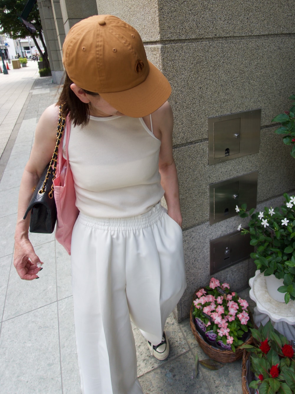 ホワイト系のパンツ、イエロー系のキャップを着用したレディースの秋コーディネートの3枚目の写真