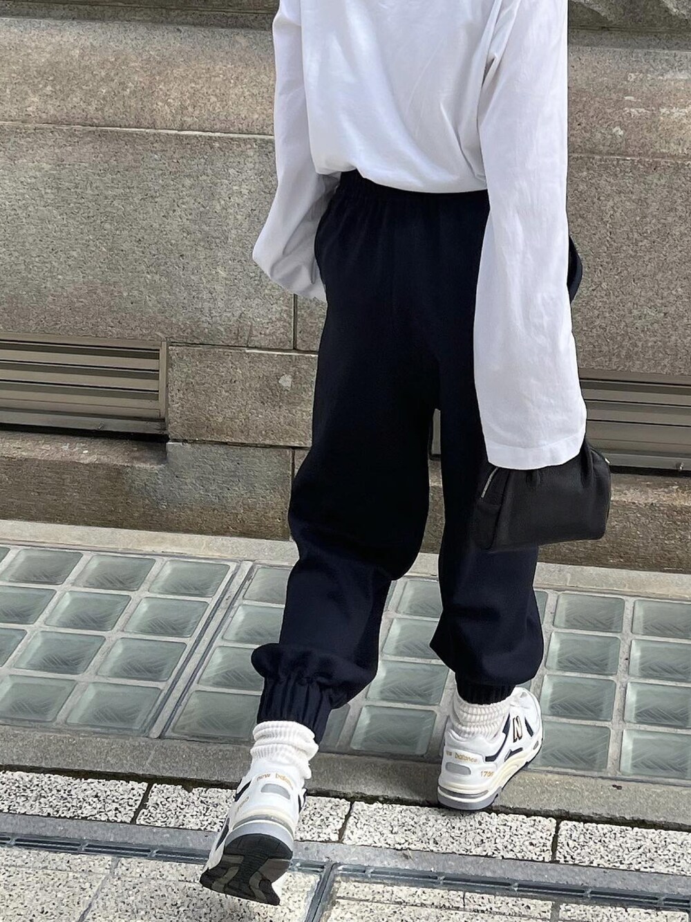 ブルー系のスラックス、ホワイト系のTシャツ/カットソー、ブラック系のドレスシューズを着用したレディースの秋コーディネートの2枚目の写真