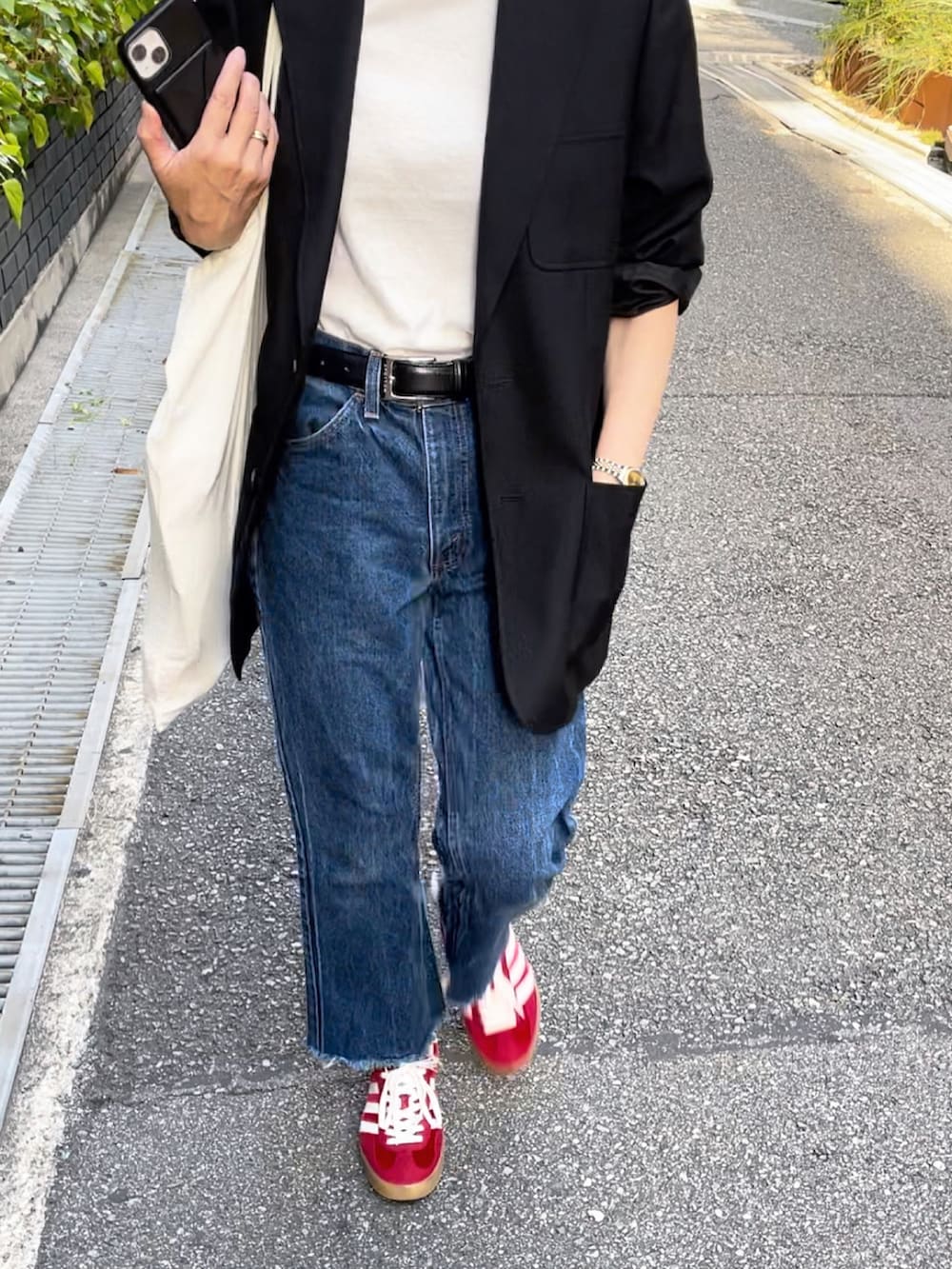 ブラック系のテーラードジャケット、ホワイト系のTシャツ/カットソー、レッド系のスニーカーを着用したレディースの秋コーディネートの3枚目の写真