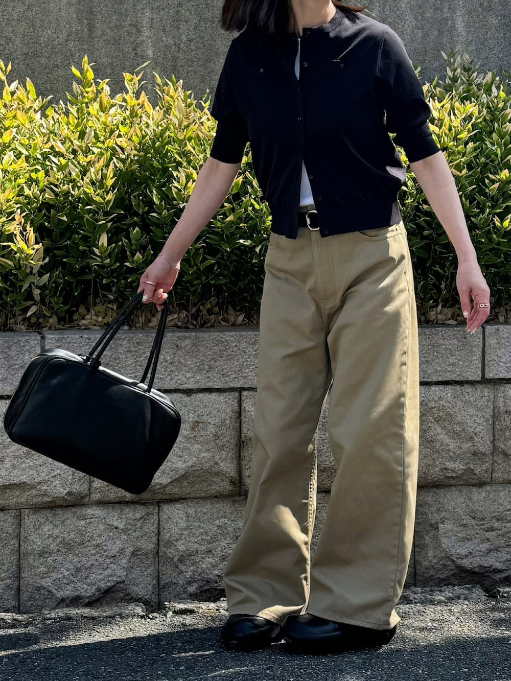 ブラック系のカーディガン/ボレロ、ベージュ系のチノパンツ、ブラック系のその他シューズを着用したレディースの春コーディネートの2枚目の写真