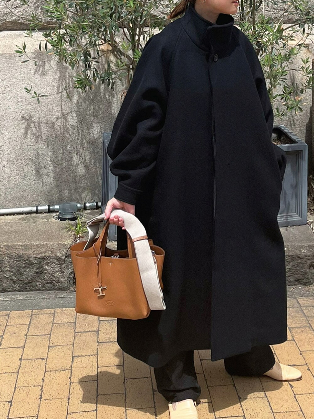 ブラック系のパンツを着用したレディースの秋コーディネートの4枚目の写真