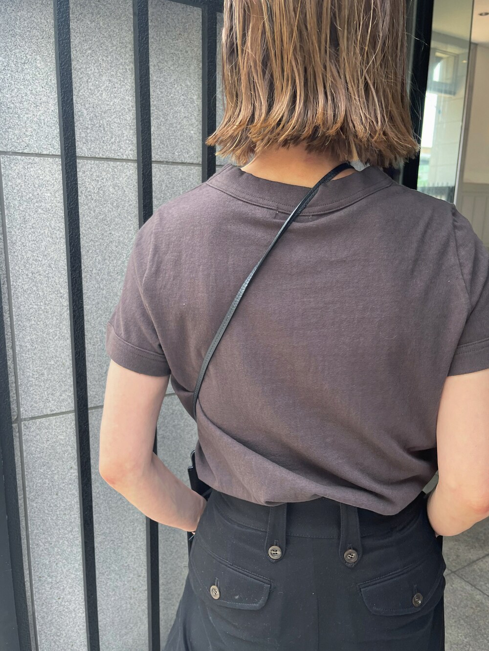 ブラウン系のTシャツ/カットソー、ブラック系のチノパンツ、ブラック系のサンダルを着用したレディースの夏コーディネートの3枚目の写真