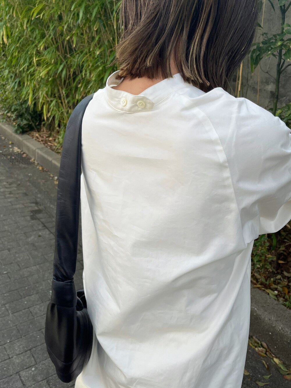 ホワイト系のシャツ/ブラウス、ホワイト系のパンツ、ブラック系のブーツを着用したレディースの春コーディネートの4枚目の写真