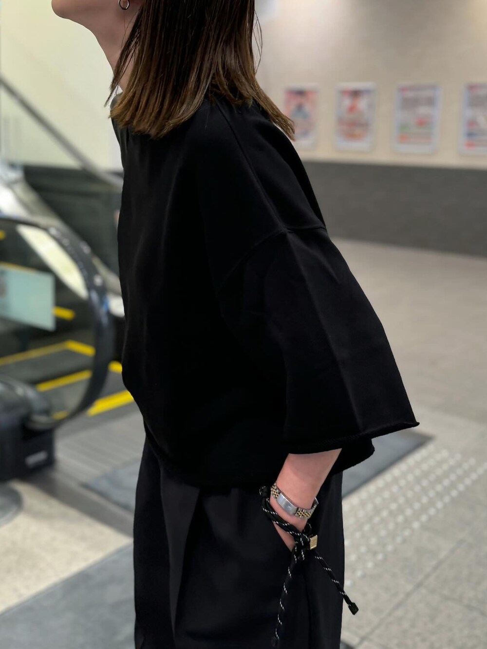 ブラック系のTシャツ/カットソー、ブラック系のパンツ、ブラック系のショルダーバッグを着用したレディースの夏コーディネートの3枚目の写真