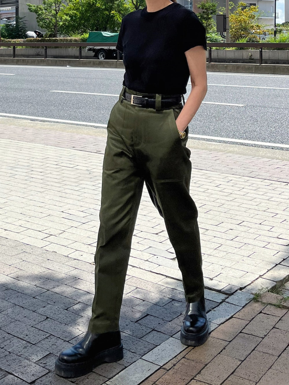 グリーン系のパンツ、ブラック系のブーツ、シルバー系のブレスレットを着用したレディースの秋コーディネートの2枚目の写真