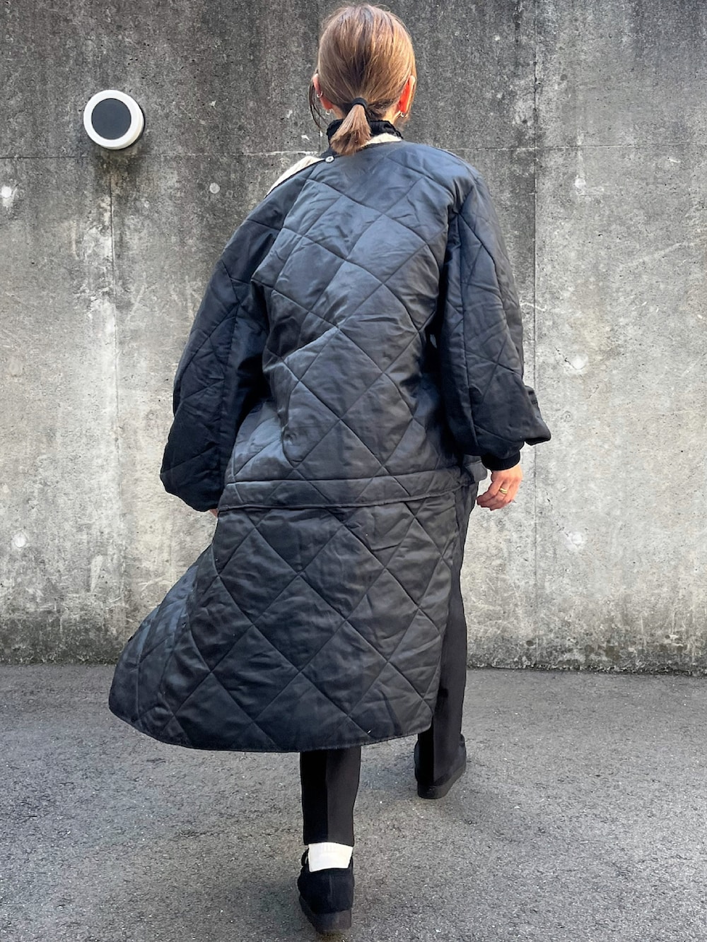 ブラック系のジャケット/アウター、ブラック系のモカシン/デッキシューズ、ブラウン系のストール/ショールを着用したレディースの冬コーディネートの4枚目の写真