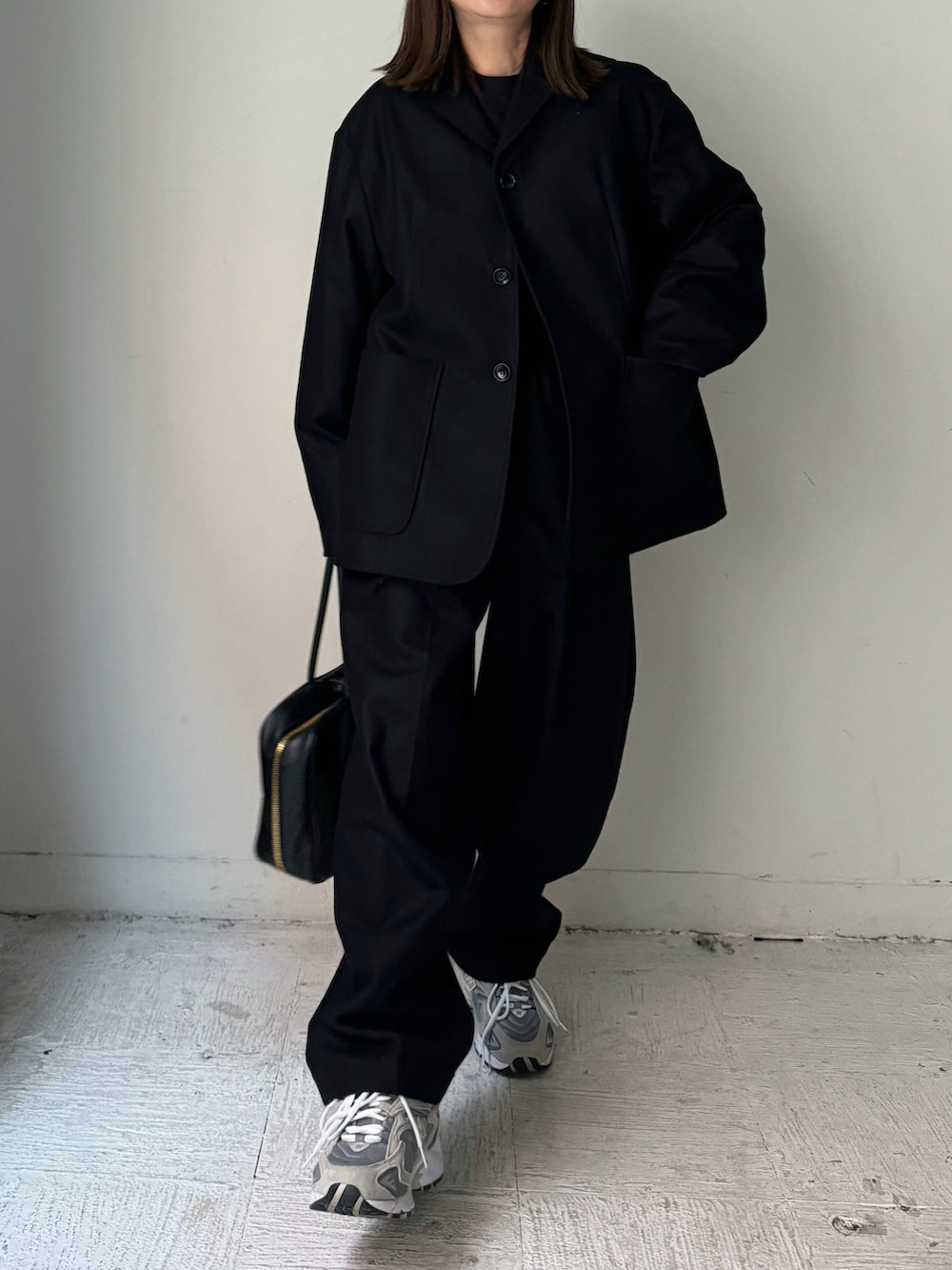 ブラック系のテーラードジャケット、ブラック系のスラックス、グレー系のカーディガン/ボレロを着用したレディースの秋コーディネートの4枚目の写真