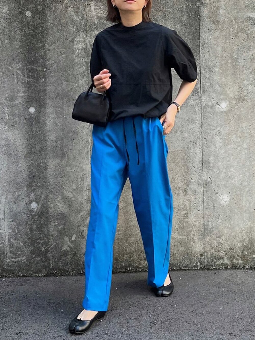 ブルー系のその他パンツ、ブラック系のシャツ/ブラウス、ブラック系のボストンバッグを着用したレディースの秋コーディネートの3枚目の写真