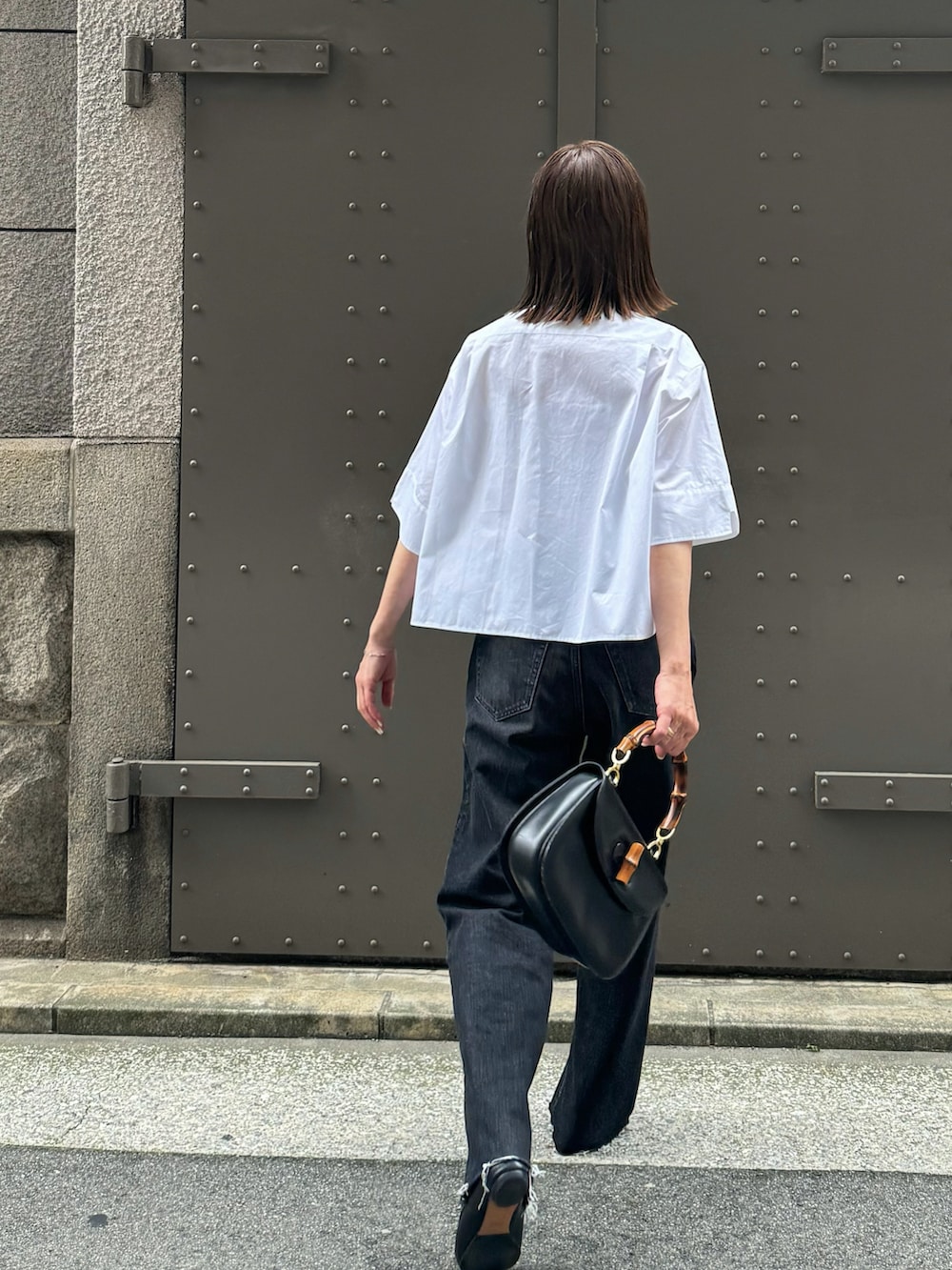 ブラック系のデニムパンツ、ホワイト系のシャツ/ブラウス、ブラック系のバレエシューズを着用したレディースの春コーディネートの3枚目の写真