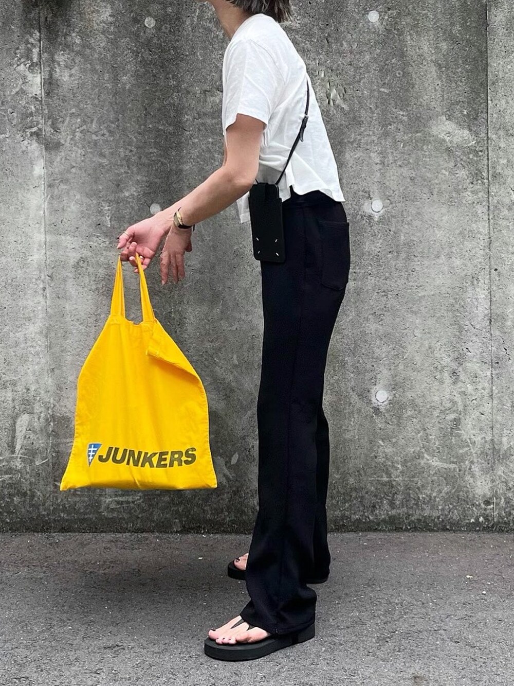 ブラック系のその他パンツ、ブラック系のスマホケース/カバーを着用したレディースの夏コーディネートの3枚目の写真