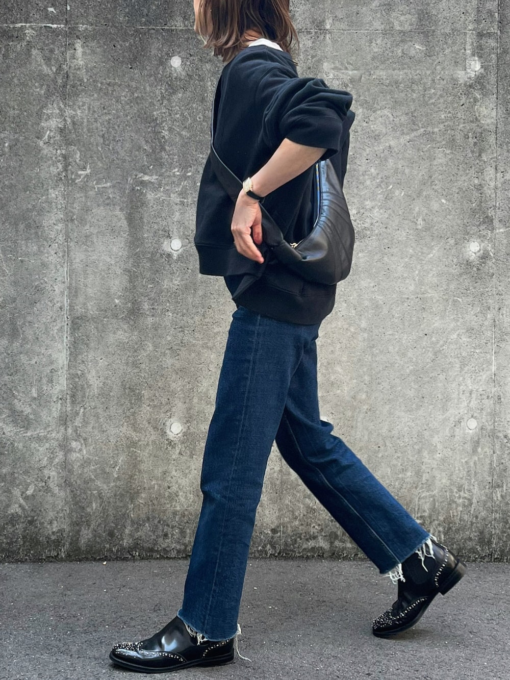 ブラック系のショルダーバッグ、ブラック系のブーツを着用したレディースの春コーディネートの2枚目の写真