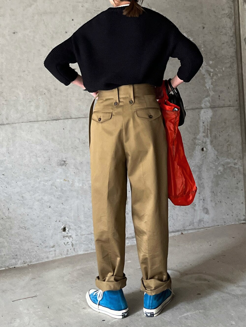 ベージュ系のチノパンツ、オレンジ系のエコバッグ/サブバッグ、ブラック系のボストンバッグを着用したレディースの冬コーディネートの5枚目の写真