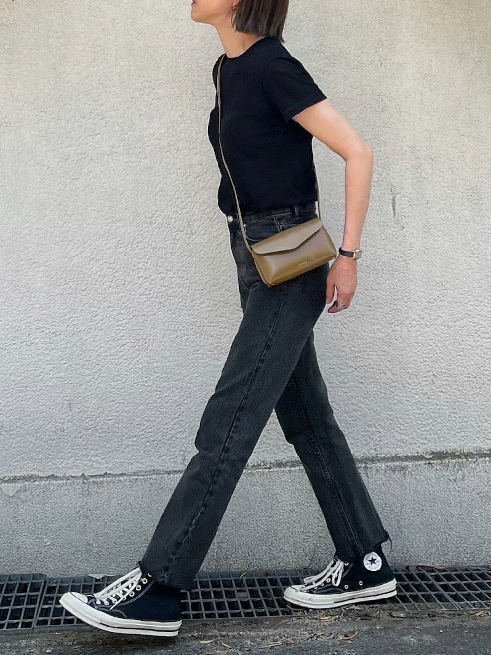 ブラウン系のショルダーバッグ、ブラック系のデニムパンツ、ブラック系のスニーカーを着用したレディースの夏コーディネートの2枚目の写真
