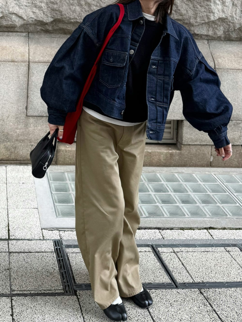 ベージュ系のチノパンツ、ブルー系のデニムジャケット、ブラック系のバレエシューズを着用したレディースの春コーディネートの2枚目の写真