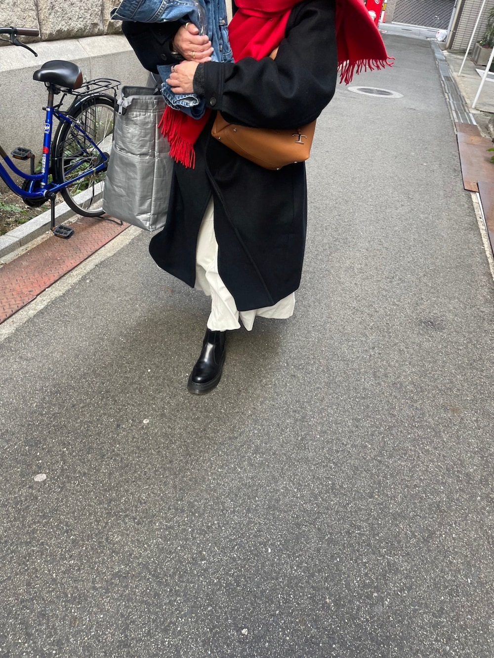 ブラック系のジャケット/アウター、ブラック系のブーツ、ホワイト系のワンピースを着用したレディースの冬コーディネートの3枚目の写真