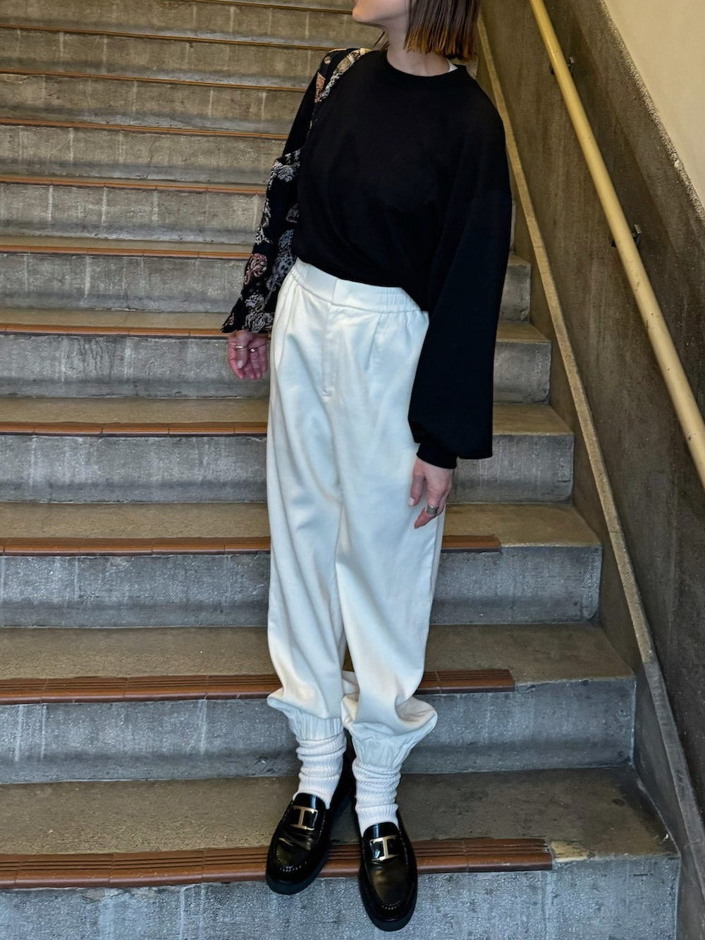 ブラック系のTシャツ/カットソー、ホワイト系のパンツ、ブラック系のローファーを着用したレディースの冬コーディネートの3枚目の写真