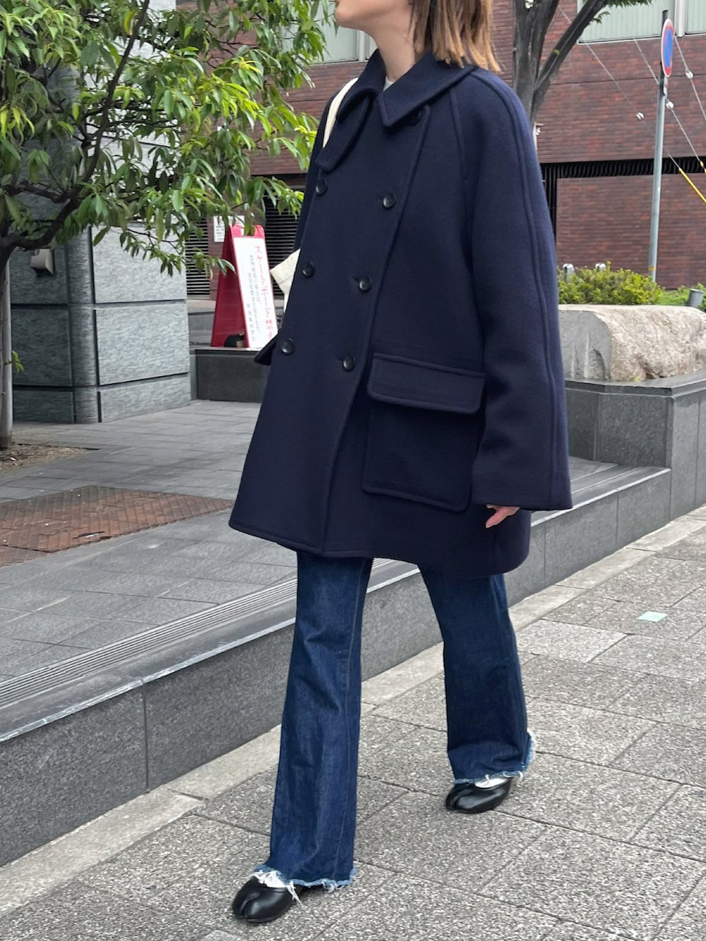 ブラック系のバレエシューズ、ブルー系のピーコート、シルバー系のピアス（両耳用）を着用したレディースの秋コーディネートの3枚目の写真