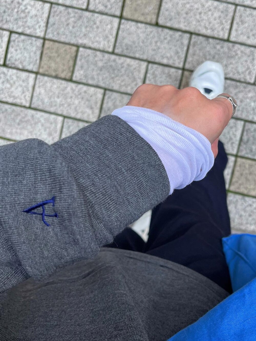 グレー系のトップス、ホワイト系のTシャツ/カットソー、ブルー系のスラックスを着用したレディースの冬コーディネートの4枚目の写真