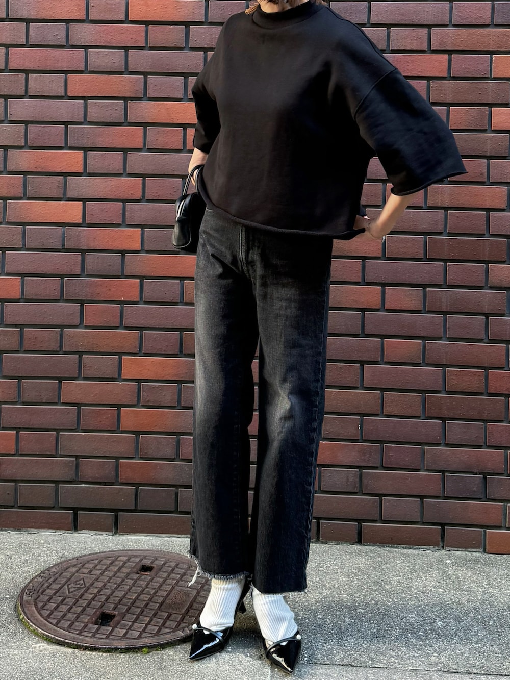 ブラック系のTシャツ/カットソー、ブラック系のデニムパンツ、シルバー系のリングを着用したレディースの春コーディネートの5枚目の写真