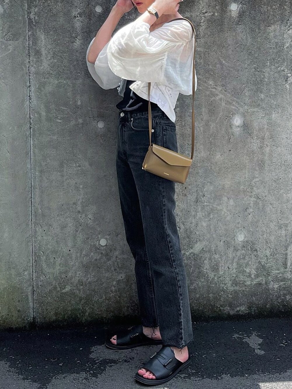 ブラウン系のショルダーバッグ、ブラック系のサンダルを着用したレディースの夏コーディネートの2枚目の写真