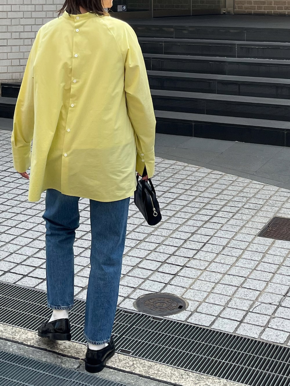 イエロー系のシャツ/ブラウス、ブラック系のボストンバッグ、ブラック系のローファーを着用したレディースの春コーディネートの3枚目の写真