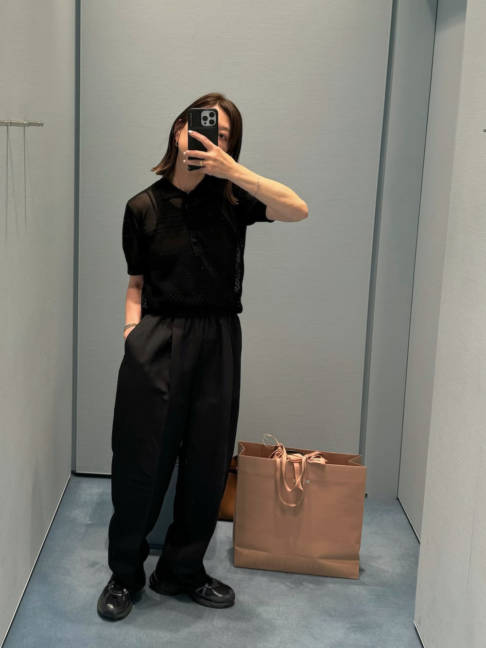 ブラック系のニット/セーター、ブラック系のパンツ、ゴールド系のピアス（両耳用）を着用したレディースの春コーディネートの2枚目の写真