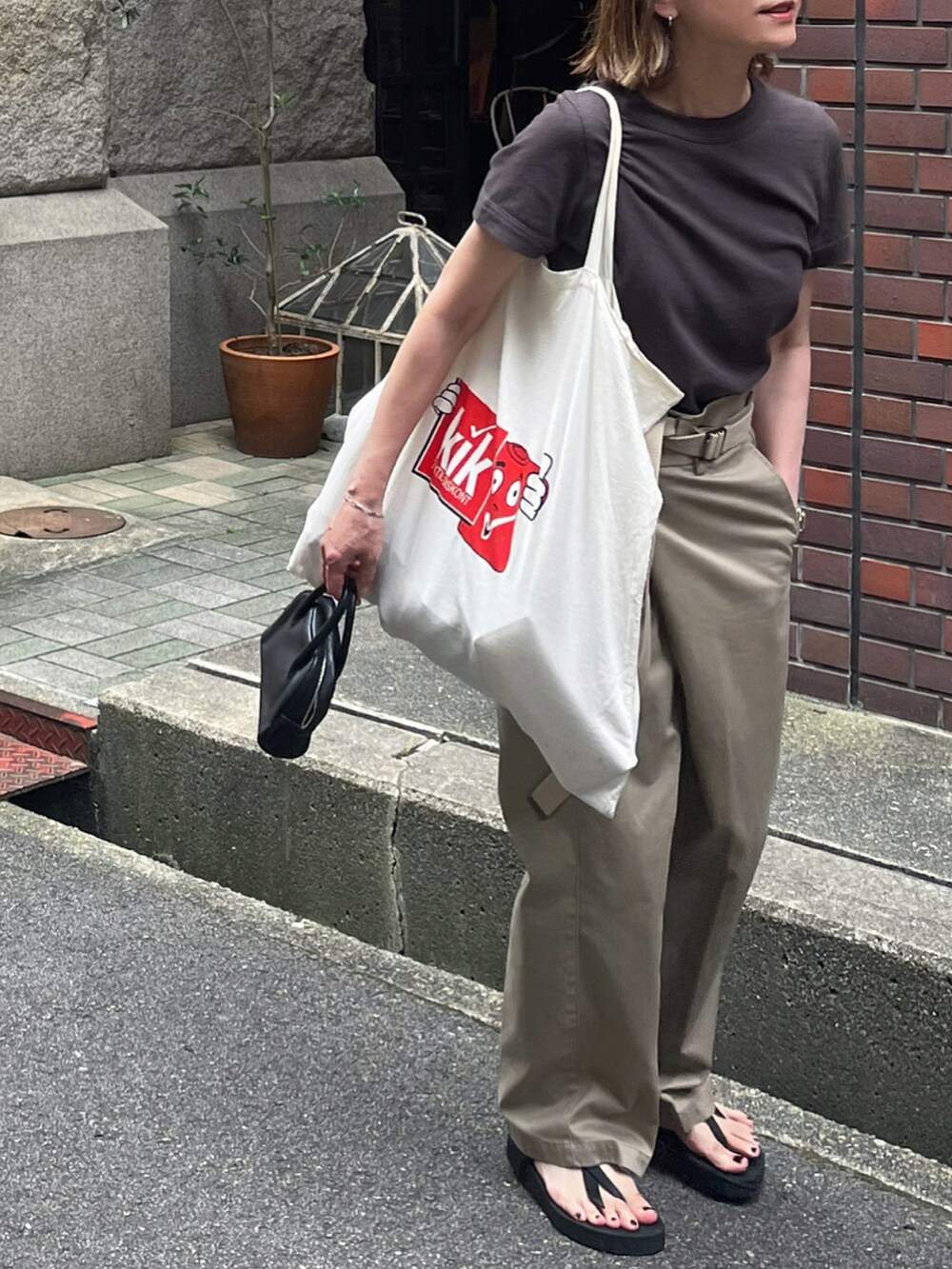 ブラウン系のTシャツ/カットソー、ベージュ系のその他パンツ、ブラック系のサンダルを着用したレディースの夏コーディネートの2枚目の写真