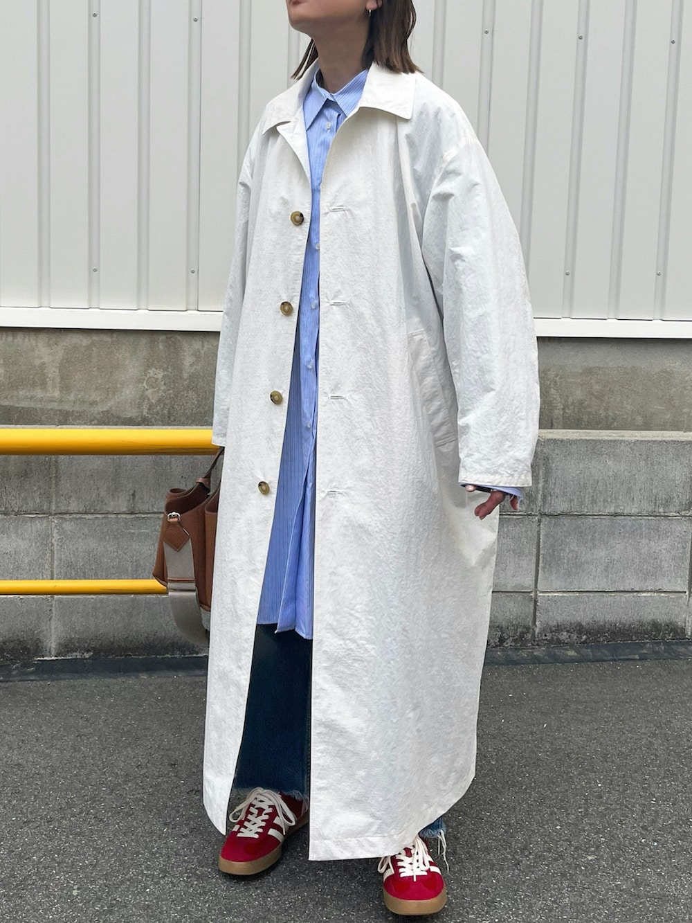 ブルー系のシャツ/ブラウス、ホワイト系のジャケット/アウター、レッド系のスニーカーを着用したレディースの冬コーディネートの2枚目の写真