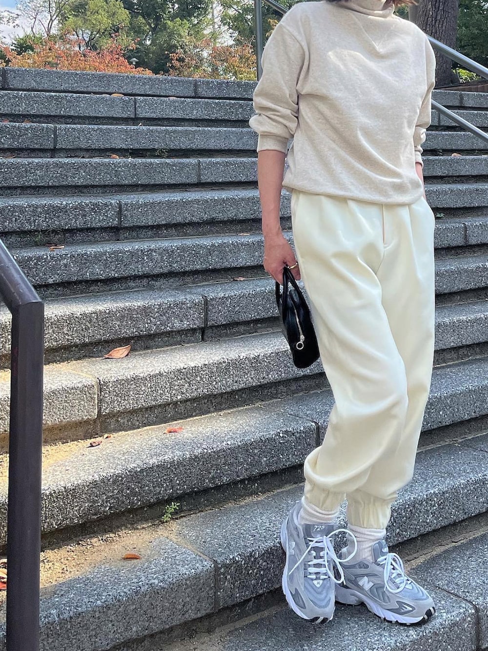 ホワイト系のスウェット、ホワイト系のパンツ、ブラック系のボストンバッグを着用したレディースの秋コーディネートの4枚目の写真