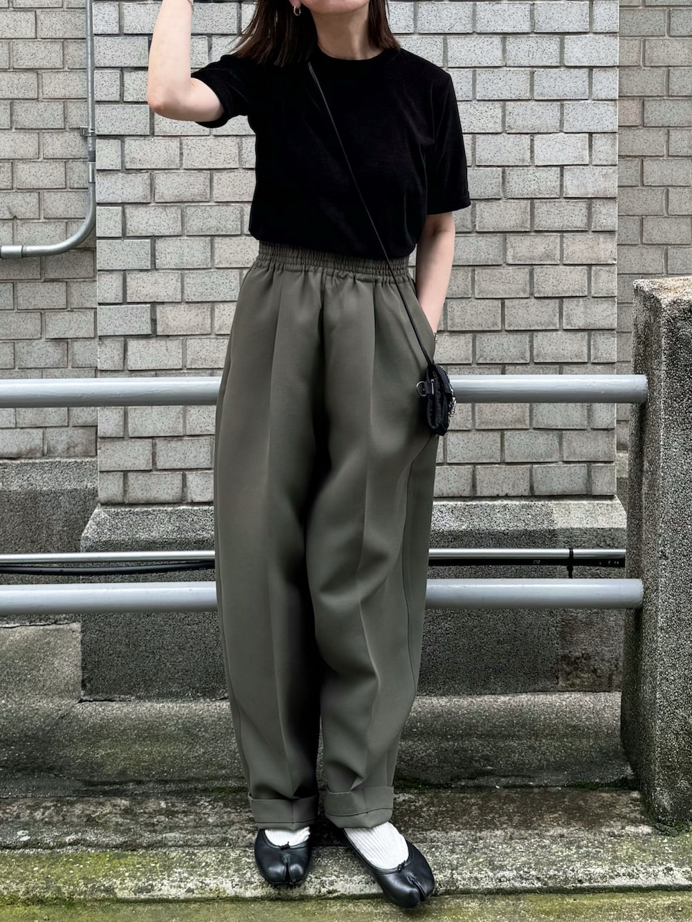 ブラック系のTシャツ/カットソー、グリーン系のパンツ、ブラック系のバレエシューズを着用したレディースの夏コーディネートの2枚目の写真