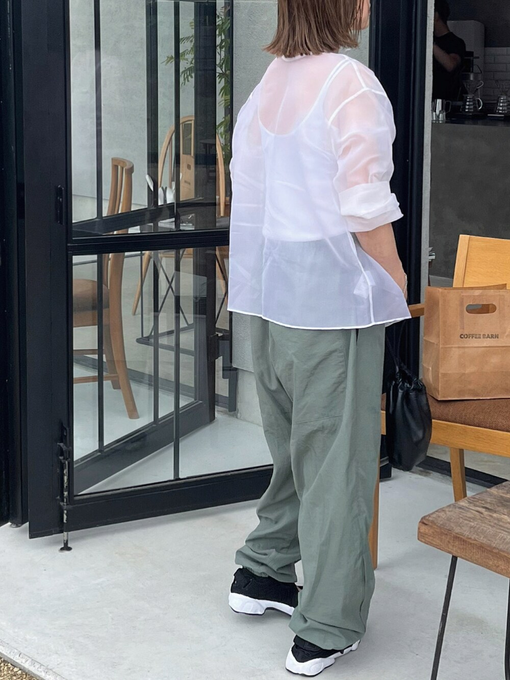 ホワイト系のシャツ/ブラウス、ブラック系のスニーカーを着用したレディースの夏コーディネートの4枚目の写真