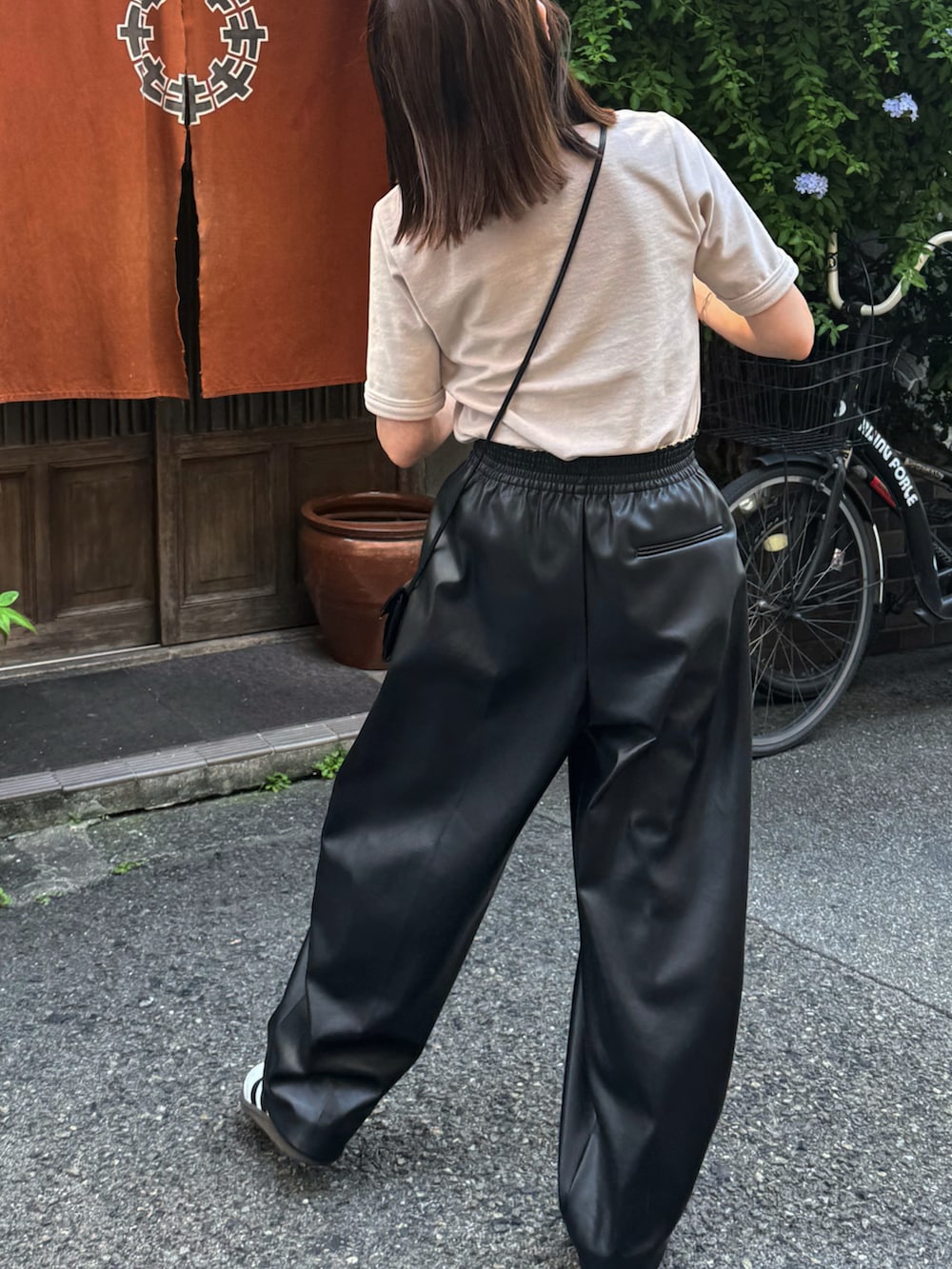 ベージュ系のTシャツ/カットソー、ブラック系のパンツ、ホワイト系のスニーカーを着用したレディースの夏コーディネートの3枚目の写真